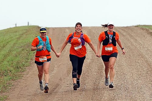 Laura Van Mulligan, Marcy Goetz and Angela Miller hold hands while reaching the finish line in the fifth annual Reconciliation Run half marathon from the former Birtle Residential School site to Birdtail Sioux First Nation on Saturday. (Tim Smith/The Brandon Sun)