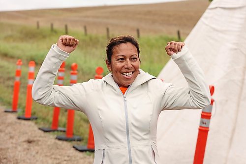 Cecile Murdock of Pinaymootang First Nation celebrates while reaching the finish line Saturday's half marathon. (Tim Smith/The Brandon Sun)