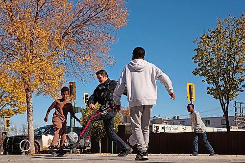 Brandon Police Service officers Const. Fabian Toews and Const. Jerra Green (not shown) play soccer with kids on their school lunch break outside the A.R. McDiarmid Civic Complex in Brandon on a sunny Thursday. (Tim Smith/The Brandon Sun)