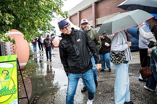 MIKAELA MACKENZIE / FREE PRESS
	
Scott Gillingham dodges umbrellas at a rainy football game at St. Paulճ on Saturday, Sept. 26, 2026.

For Malak day-in-the-life story.
Free Press 2026