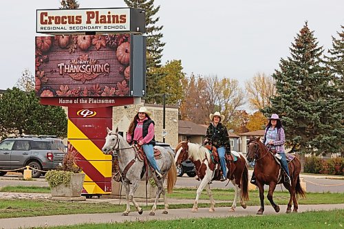 Jaiden Hayward, Brooklynn Bankert and Hope Bolstad-Duncan with Acres of Hope Stables ride horses past Crocus Plains Regional Secondary School and back toward the stables after visiting Tim Hortons on Friday morning. (Tim Smith/The Brandon Sun)