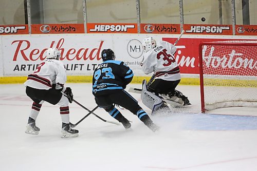 Xander Mecas pressures Virden goaltender Kasey Fuson as he plays the puck. As a veteran, Mecas plays an important role reaching the younger players on the Blues. (Rowan McCarthy/The Brandon Sun).