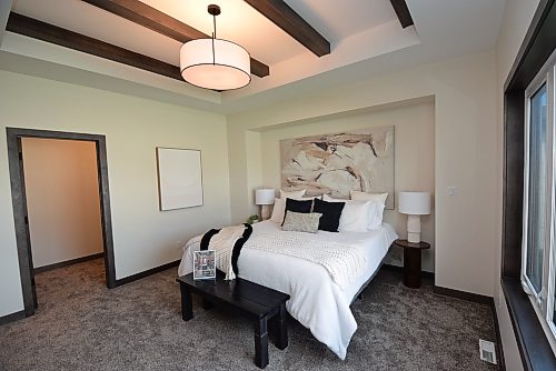Todd Lewys / Free Press 
Soft earth tones combine with a beamed tray ceiling to give the private primary bedroom a wonderful air of relaxation.