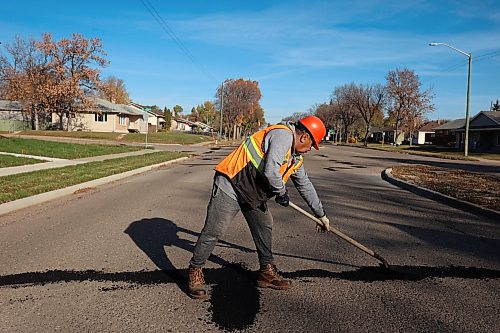 A worker with the Province of Manitoba fixes potholes along First Street in Brandon on a sunny Tuesday morning. 
(Tim Smith/The Brandon Sun)
