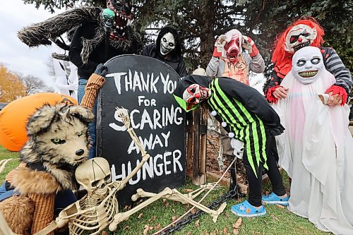 The Mitchell family, and friend Trevor Ellis, are in costume surrounding their tombstone on Friday. (Connor McDowell/The Brandon Sun)