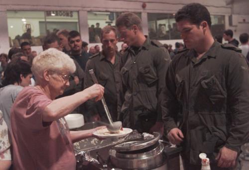 Altona Dinner- 71 yr old volunteer Mary Hiebert serves Mennonite dinner to 1PPCLI CAlgary troops private Patrick Webber,right, and private Adam Latour at a dinner put on by the town which served 650 troops,evacuees, and host families. Joe Bryksa-Winnipeg Free Press