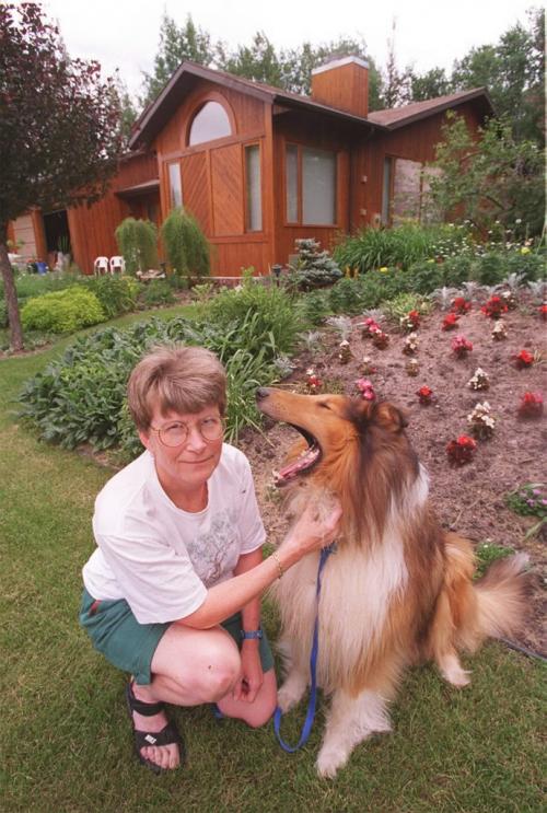 wfp102--pinawa--marsha shepard, enviornmental scientist at aecl, infroont of her home with her dog sox.---july 18.97--jeff de booy-- winnipeg free press