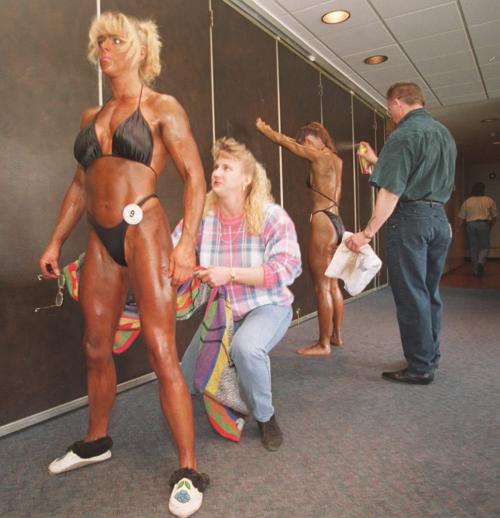 wfp103--winnipeg-- 1996 MANITOBA NOVICE BODY BUILDING CHAMPIONSHIPS  IN  THE  MULTI PURPOSE ROOM AT THE U OF M.. PREPARING THE SHINY LOOK FOR COMPETION   IS LEFT #9  TRICIA CHMILOWSKY GETS WIPE DOWM FROM FRIEND PETULA GILLINGHAM AS  VAL RODGERS ( FROM BRANDON) GETS THE PAM SPRAY DOWN  BY HER TRAINER GREG LOWE..PHOTO WAYNE GLOWACKI.. MARCH 10 96 winnipeg free press