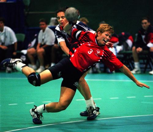Canada's Dominique Boivin (3) is pushed by USA's Keri Farley as she flies in for a throw on the American net during the first half of team handball action at the  Pan American Games in Winnipge Aug.4, 1999. Farley was given a yellow card for rough play and Canada scored on the ensuing penalty shot. (CP PHOTO/Tim Krochak-Winnipeg Free Press)