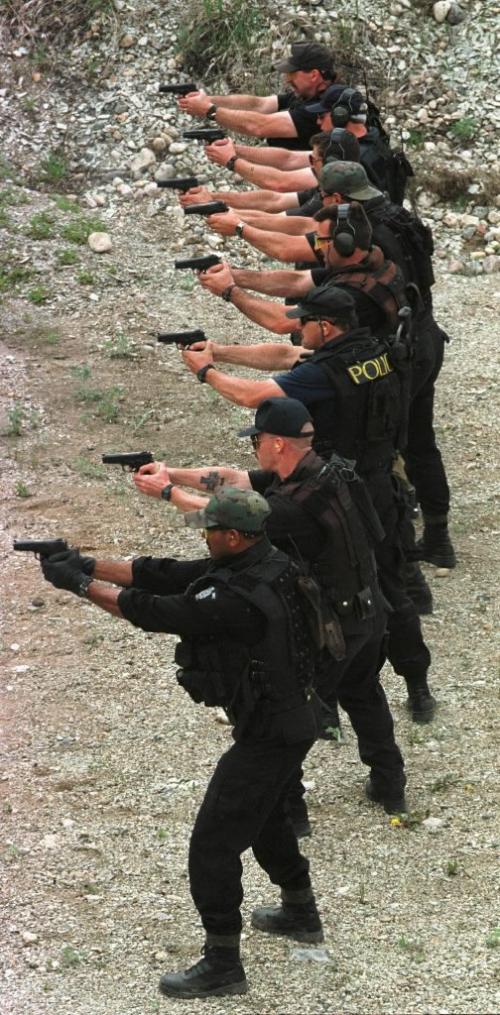 May 26, 1999--Rossburn, MB--RCMP Emergency Response Team (ERT) members fire their Smith and Wesson pistols during drills at a gravel pit near their camp. RCMP from around the province are currently on two day exercises near Rossburn. Photo by Fred Greenslade