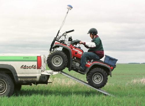 May 21, 1999--Elm Creek, MB--Agronomist Oscar Perez drives ATV loaded up with global positioning system and computers off of truck as he gets ready to do research in Darryl Enns' field near Elm Creek. Photo by Fred Greenslade