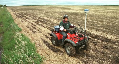 May 21, 1999--Elm Creek, MB--Agronomist Oscar Perez drives ATV loaded up with global positioning system and computers around Darryl Enns' field near Elm Creek checking for weed density. Photo by Fred Greenslade