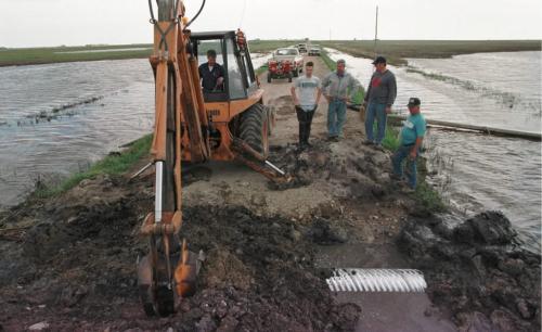 May 19, 1999--Melita, MB--The Melita area Barker family works on putting in a culvert between two of their fields Wednesday afternoon in an attempt to help alleviate some of their water problems on their fields. The family has seeded roughly 90 acres out of the 3400 they farm. Photo by Fred Greenslade