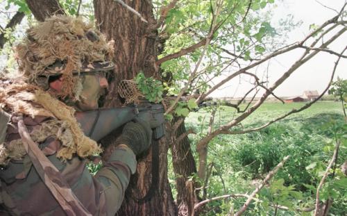 May 27, 1999--Rossburn, MB--ERT member keeps an eye on farmhouse during exercises north of Rossburn. RCMP from around the province are currently on two day exercises near Rossburn. Photo by Fred Greenslade