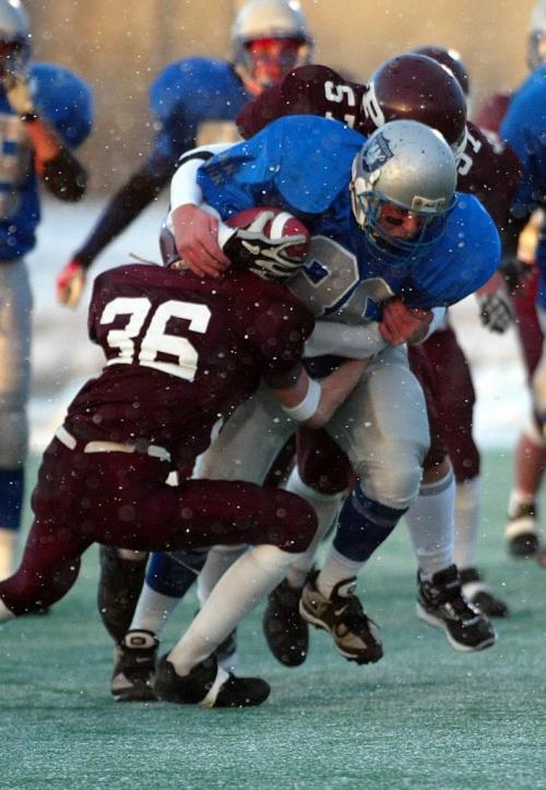ken gigliotti/ winnipeg free press / oct 31 2003  St Paul's Crusaders's player  #36 Spencer Chimuk  and #57 Kevin Mitchell  stuffs run against  Oak Park Raider #36 Preston Drinnan  in  High School AA semi final game  at East side Eagles Field-kg